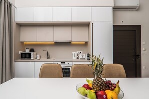 Eine moderne Küche mit weißen Schränken, einer Mikrowelle und einer Kaffeemaschine.