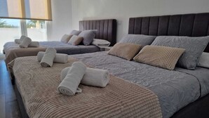 Habitació d'hotel amb dos llits, cadascun amb una tovallola arremolinada, un capçal i una finestra amb persianes.