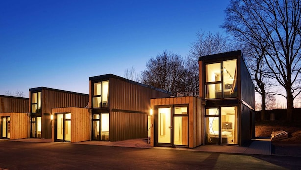 Un edificio moderno con varias unidades, ventanas amplias y techo plano.