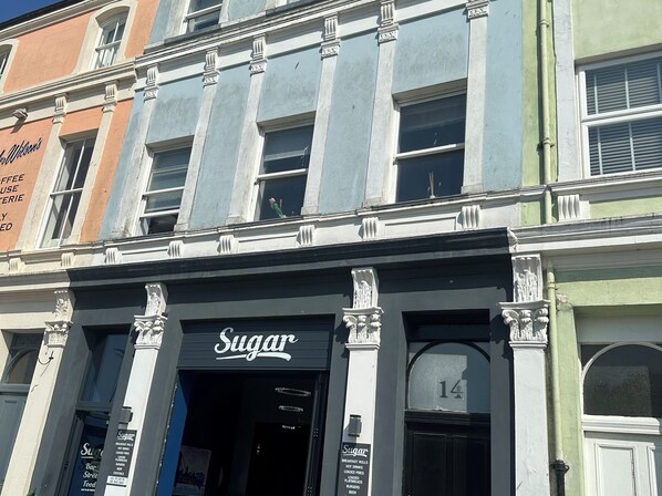 A building with a storefront labeled 'Sugar' and a number '14' above the door. - Sugar Loft (Wigton)