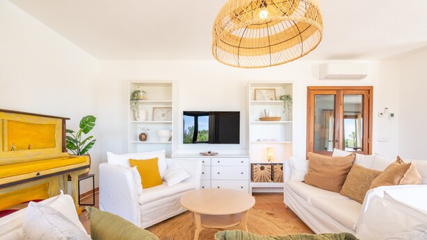 Ein modernes Wohnzimmer mit einer Couch, einem Couchtisch, einem Fernseher und einer Korbschichtlichtleuchte.
