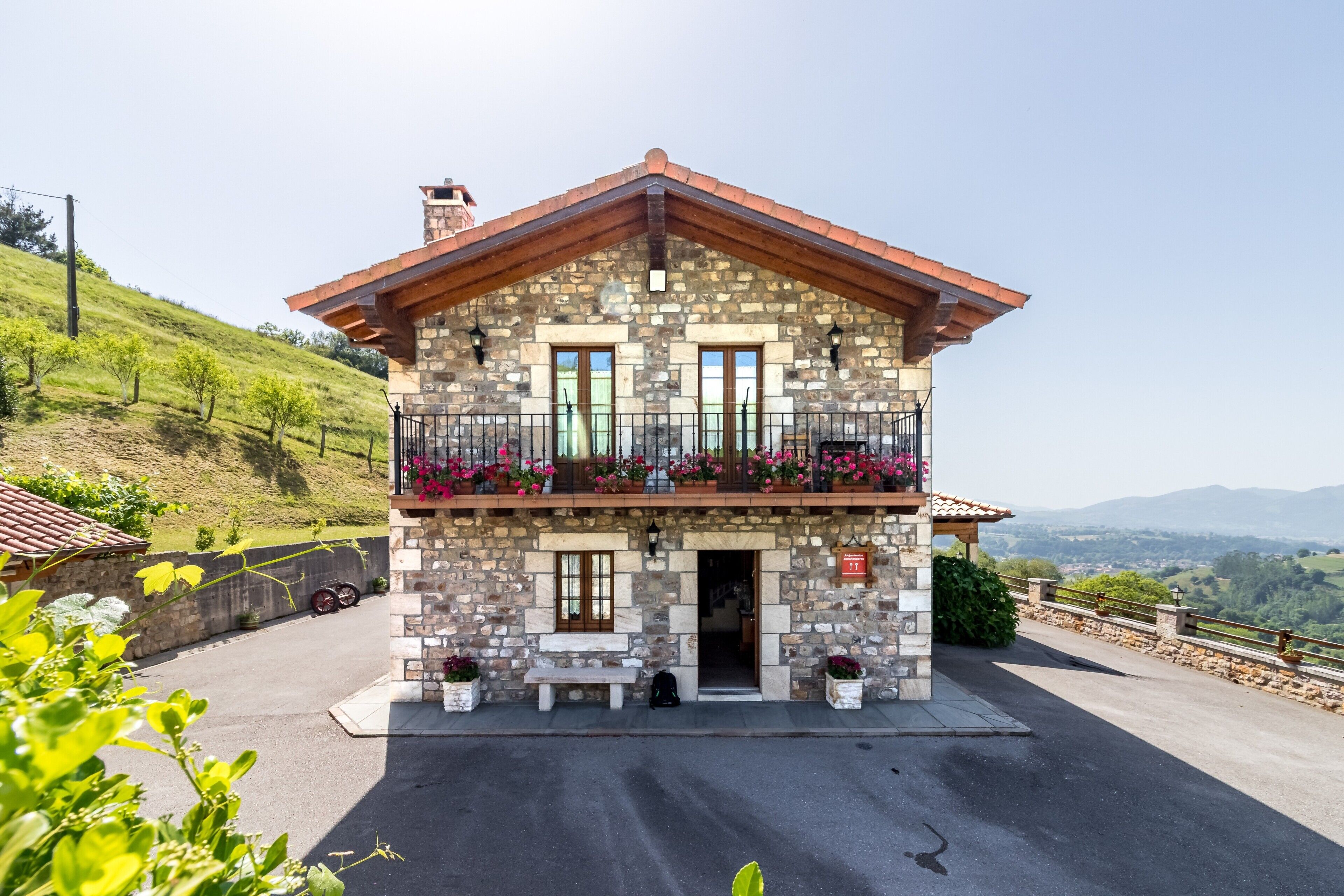 Un edificio in pietra con un balcone, una panchina e un cartello con la scritta 'Camera 11'.