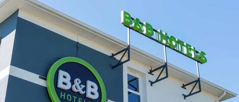 A B&B hotel sign with a circular logo and a rectangular sign above it.