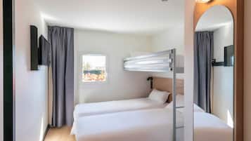 Ein Hotelzimmer mit zwei Betten, einem Fenster, einem Spiegel und einem Fernseher.