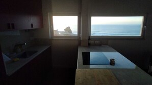 Une cuisine avec vue sur l’océan, un évier et un plan de travail.