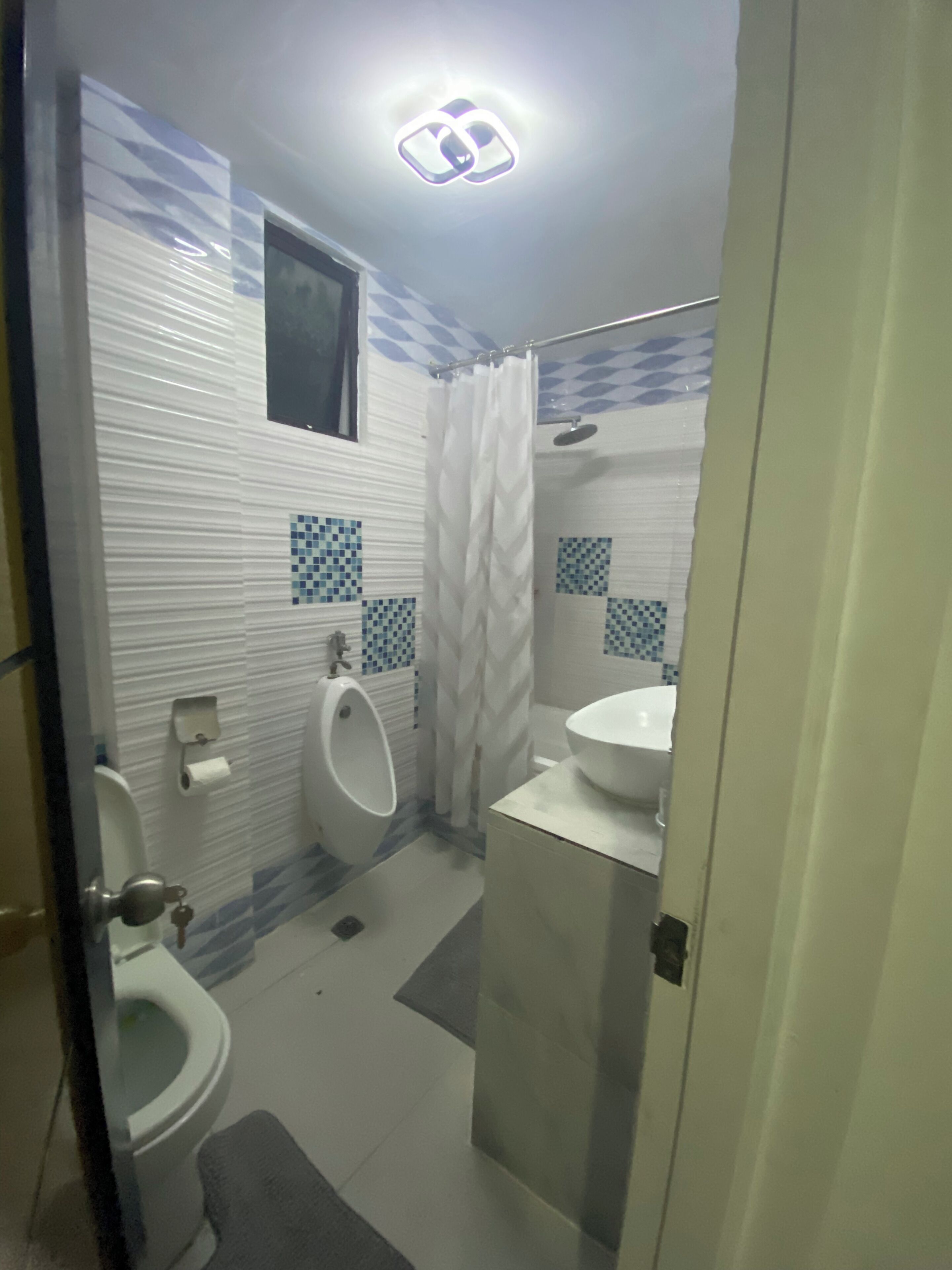 A bathroom with a toilet, urinal, and sink.