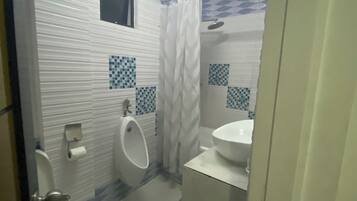 A bathroom with a toilet, urinal, and sink.