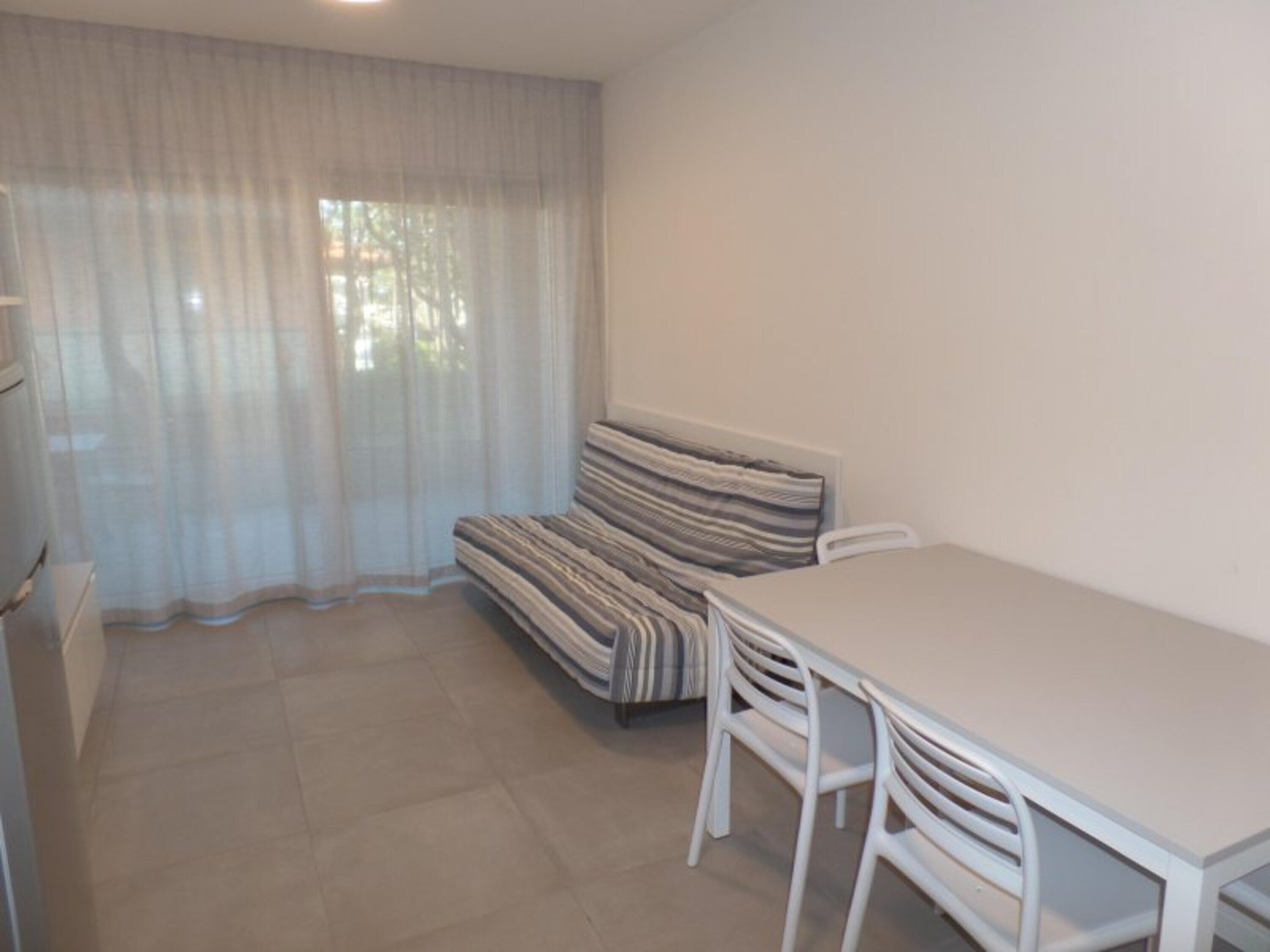 A room with a sofa, a table, and chairs.