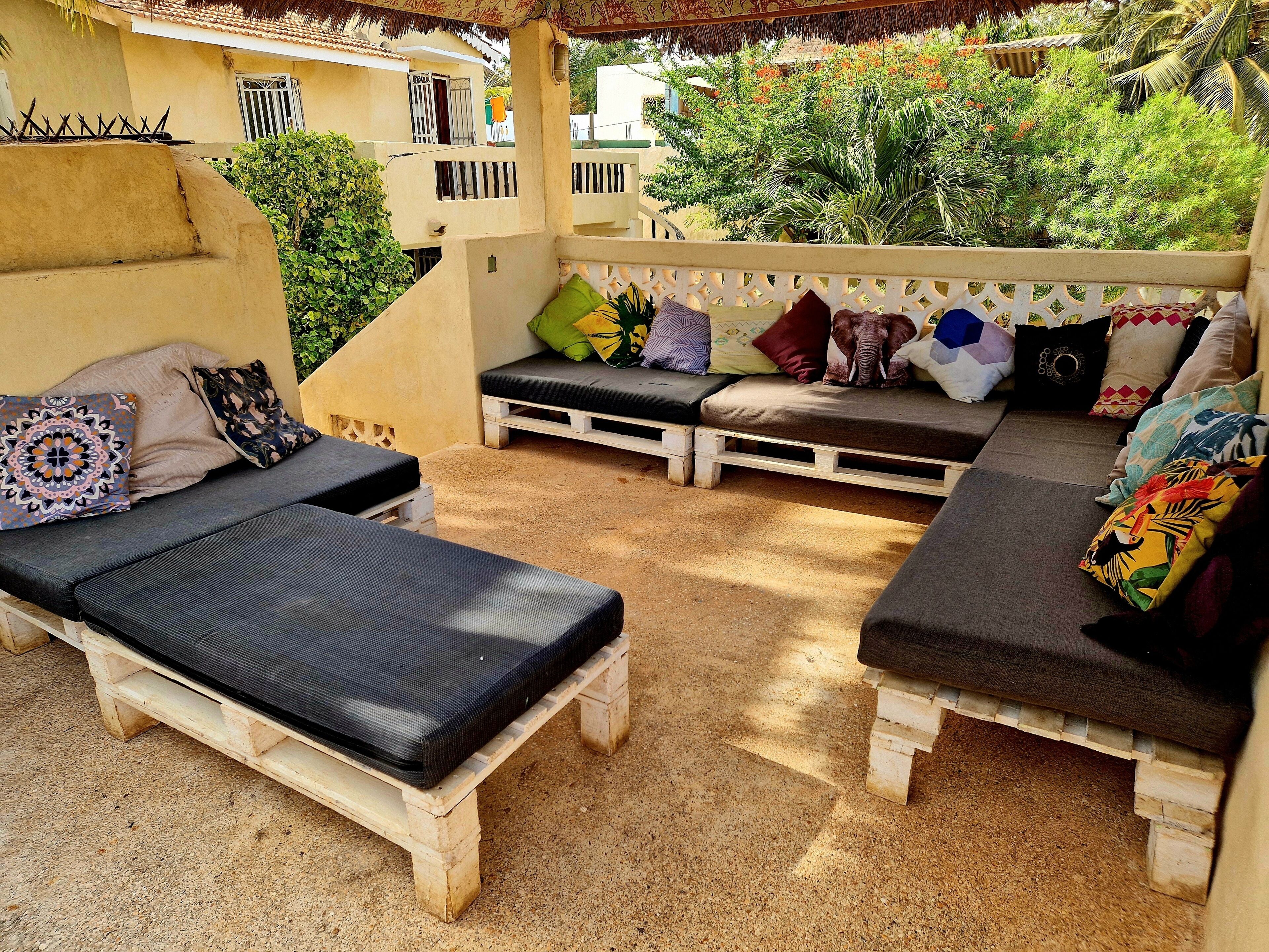 A patio with two lounge chairs, a bench, and a small table.
