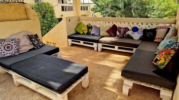 A patio with two lounge chairs, a bench, and a small table.