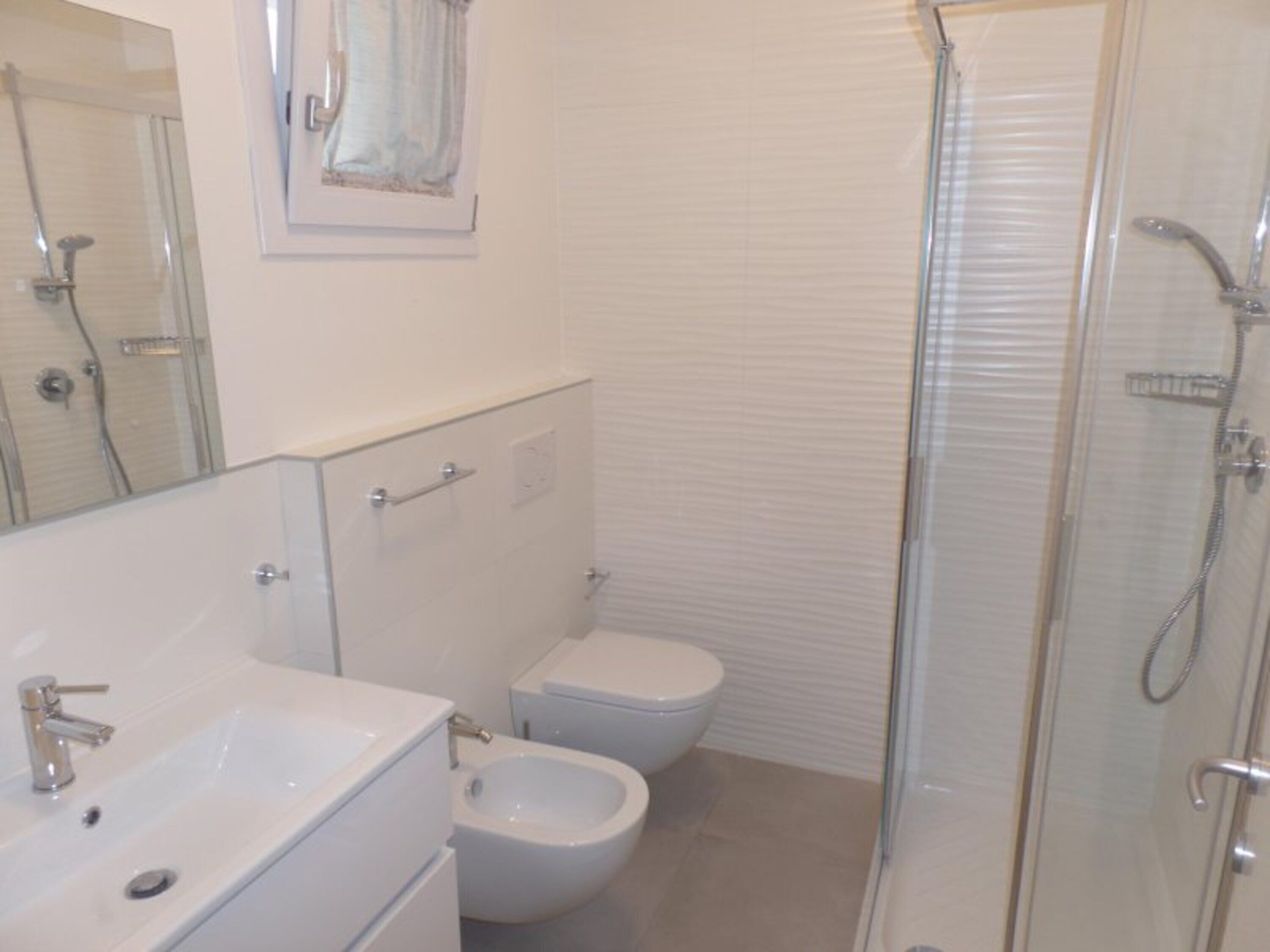 A bathroom with a shower, toilet, and sink.