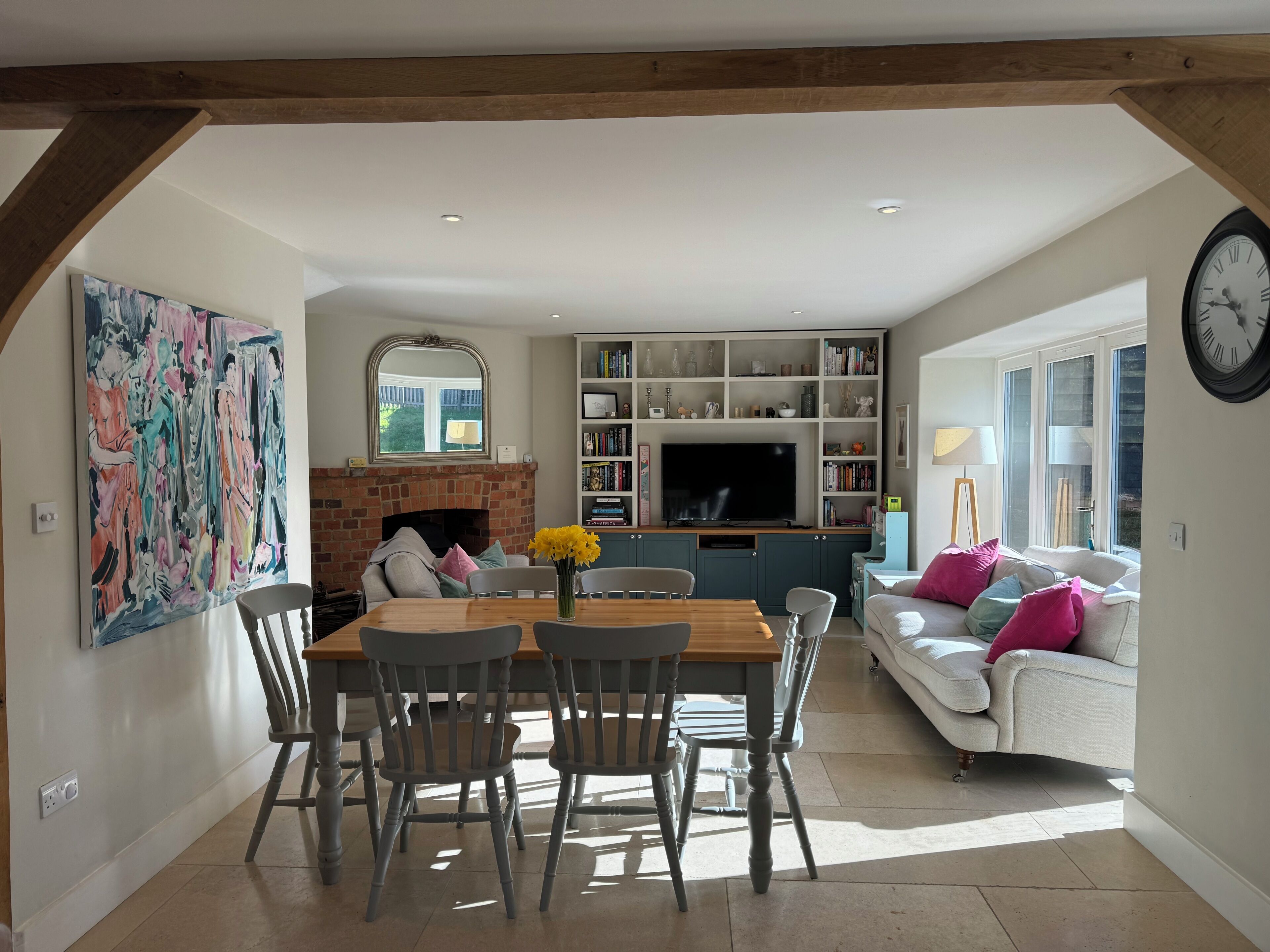 A dining area with a brick fireplace, a television, and a bookshelf.