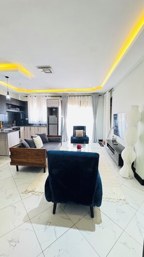 Ein modernes Wohnzimmer mit einer Couch, einem Couchtisch und einem Fernseher.