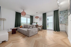 Ein modernes Wohnzimmer mit einer Couch, einem Esstisch und einem kleinen Beistelltisch.