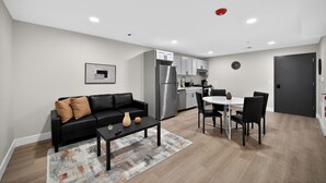 Un apartamento moderno con sala de estar, comedor, kitchenette y un dormitorio separado.