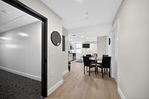 Ein modernes Interieur mit Essbereich, Küche und einem Flur, der zu einem weiteren Raum führt.