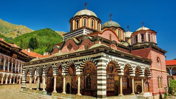 A historic building with multiple domes, arches, and a courtyard.