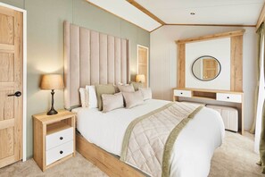 Ein Schlafzimmer mit Bett, Nachttischen, Schreibtisch, Spiegel und Kleiderschrank.