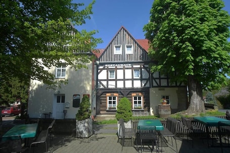 A traditional half-timbered building with a sign reading 'RESTAURANCE' and outdoor seating.. U Zeleného stromu
