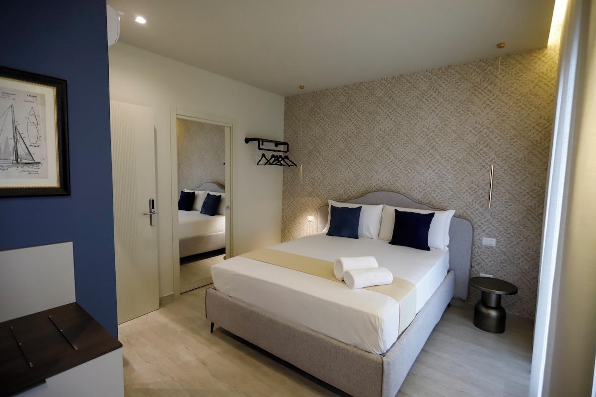 Un dormitorio con cama, mesita de noche, armario y un cuadro en la pared.
