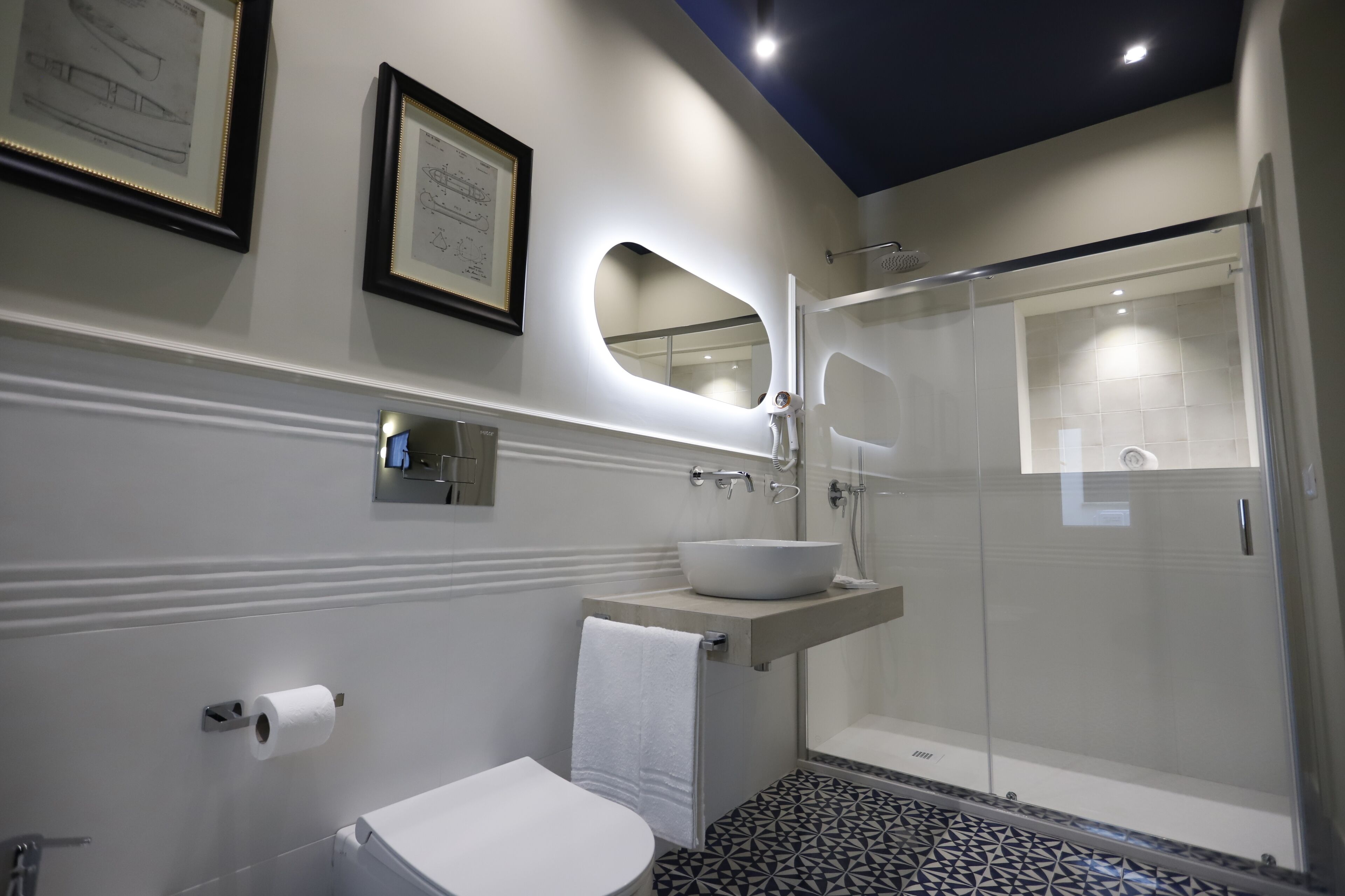 A modern bathroom with a toilet, sink, and shower.