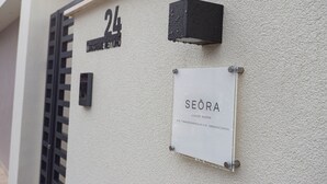 A building with a sign indicating '24' and 'SEÓRA LUXURY ROOMS' with a contact number. - Seõra Luxury Rooms (Porto Empedocle)