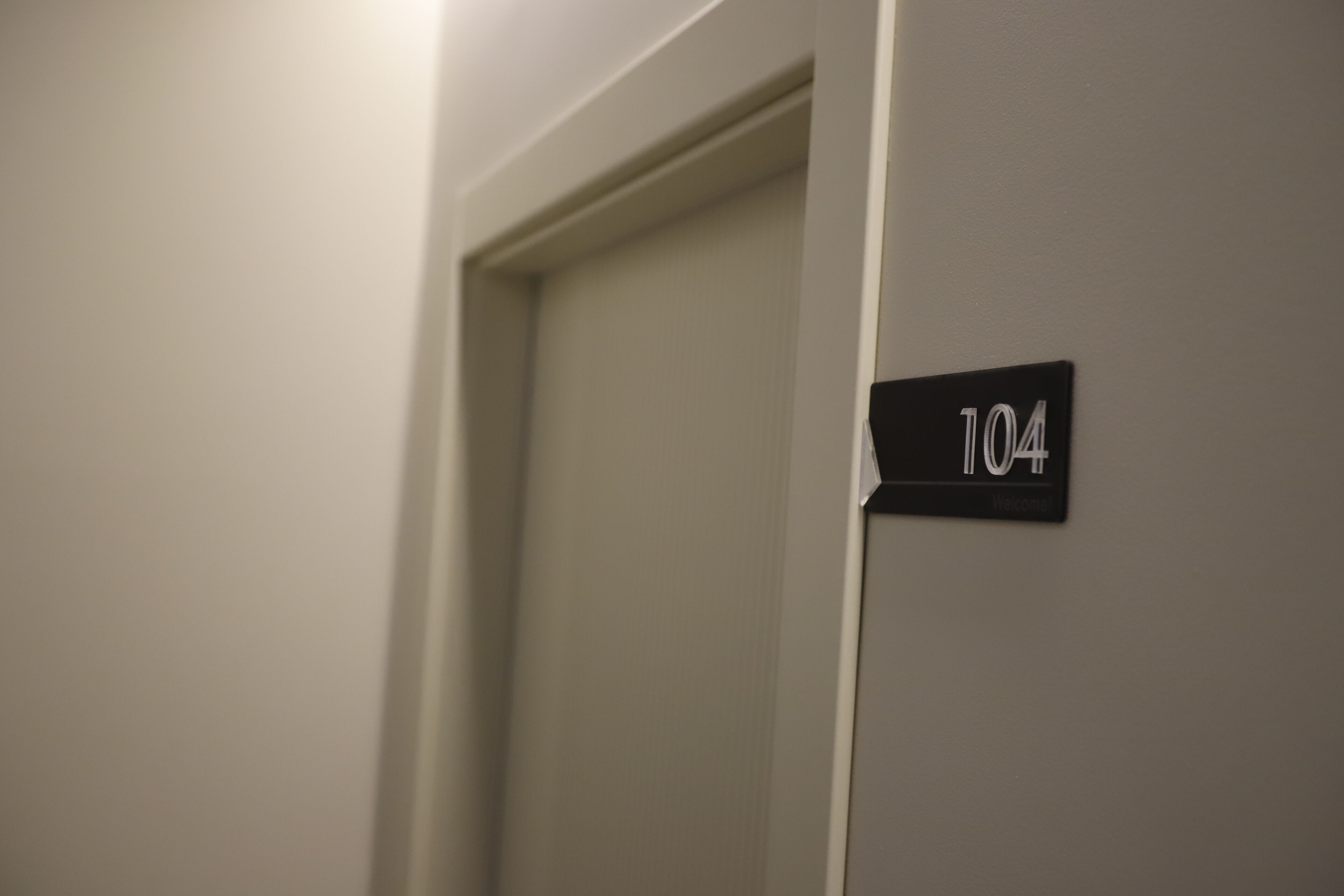 En dörr med en skylt som visar att det är rum nummer 104.