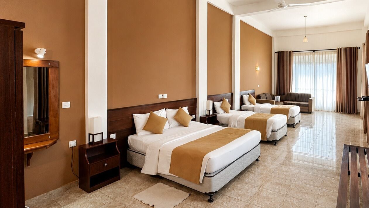 Una habitación de hotel con una cama grande, dos camas individuales, un sofá, un escritorio y un espejo.