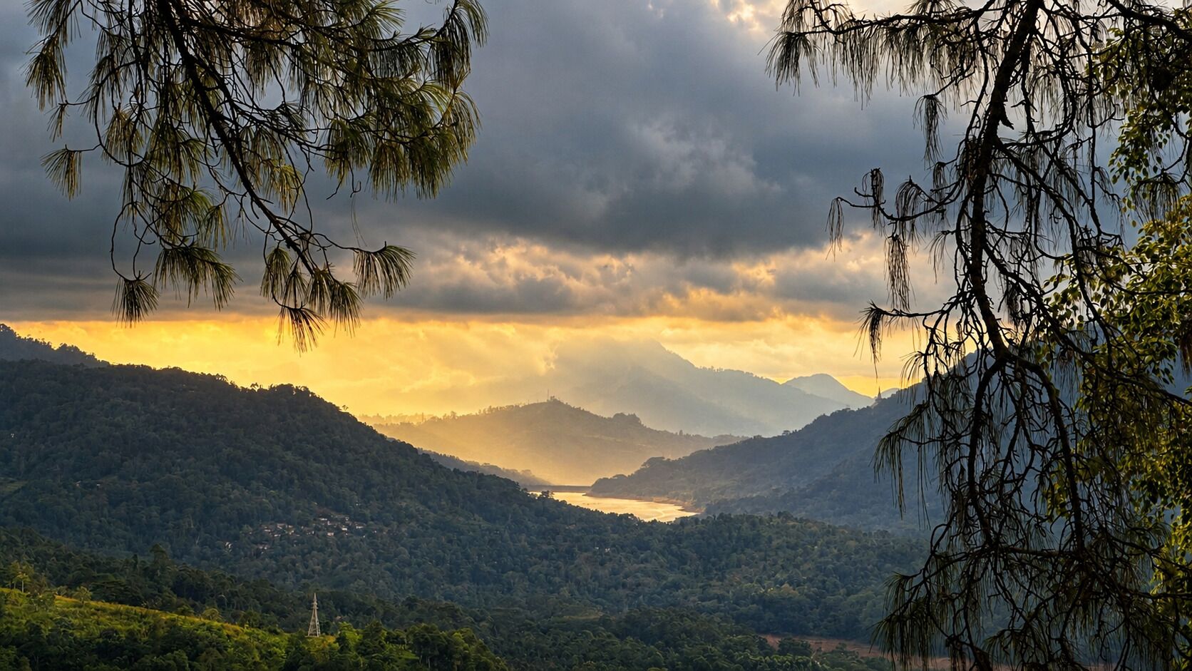A mountainous landscape with a valley and a body of water.
