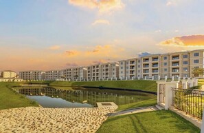 A modern hotel with a pool, green lawns, and a clear sky. - The Cozy Maison (Midrand)