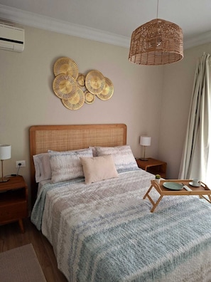 Ein Schlafzimmer mit Bett, Nachttischen, einer Hängeleuchte und Wanddekoration.