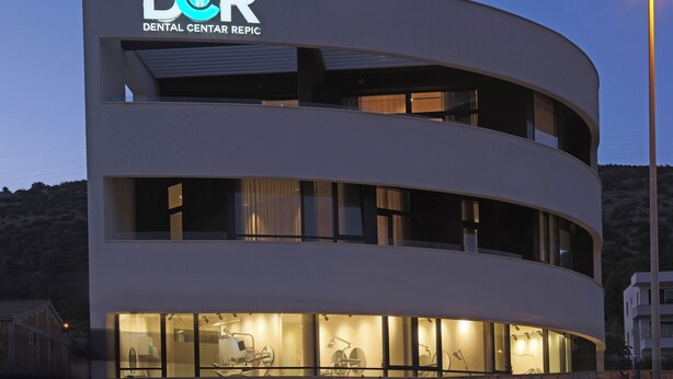 Un edificio moderno con un letrero que dice 'DCR Dental Center Repic'.