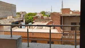 A residential area with multiple buildings, including a brick structure and a concrete building. - Gopal Dham (Mathura)