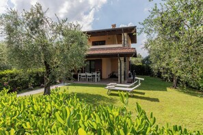 A two-story house with a patio, outdoor seating, and a well-maintained garden. - CASA SAN GIORGIO, Family Apartment (Solarolo)