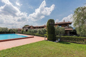 A two-story house with a swimming pool, surrounded by well-maintained lawns and hedges. - CASA SAN GIORGIO, Family Apartment (Solarolo)