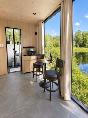 Eine moderne Küche mit Mikrowelle, einem kleinen Esstisch und Blick auf einen See.