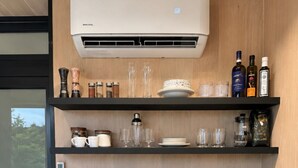 A kitchen with a coffee maker, toaster, kettle, and a paper towel dispenser.
