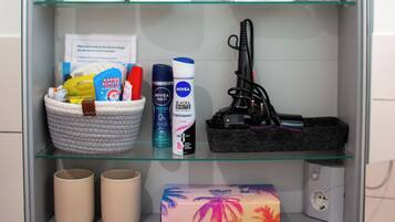 Une salle de bain avec une étagère contenant des articles de toilette, une plante et une boîte de mouchoirs.