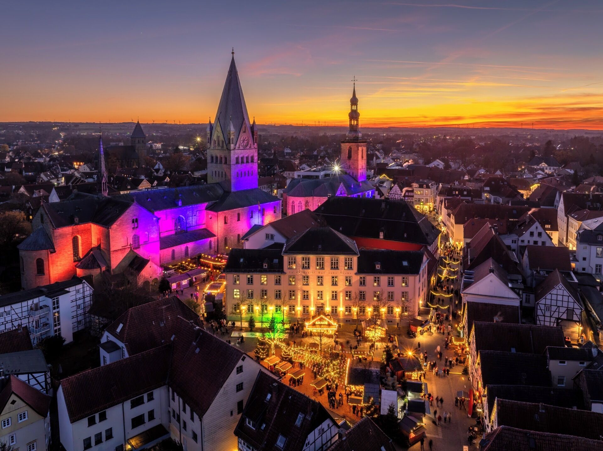 A historic town square with traditional buildings, a prominent church, and a clock tower.