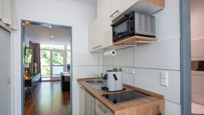 A modern kitchen with a built-in microwave, a coffee maker, and a sink. - Design-FeWo at the Möhnesee with unique lake view, balcony, pool, sauna, elevator (Möhnesee)