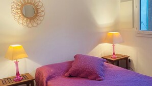 A bedroom with a bed, two bedside tables with lamps, a decorative mirror, and a window. - RESIDENCE PINARELLO CORSE SUD, MINI VILLA, SEA AND BEACH VIEW ON FOOT, for 6 (Zonza)