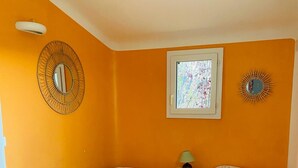 A room with two beds, a window, a mirror, and a lamp on a nightstand. - RESIDENCE PINARELLO CORSE SUD, MINI VILLA, SEA AND BEACH VIEW ON FOOT, for 6 (Zonza)