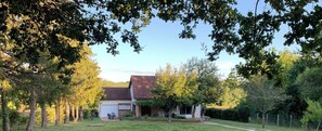 Ein Wohnhaus mit freistehendem Haus, Garage und gepflegtem Rasen.