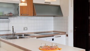 Eine moderne Küche mit weißen Schränken, Edelstahlgeräten und einer Holzarbeitsplatte.