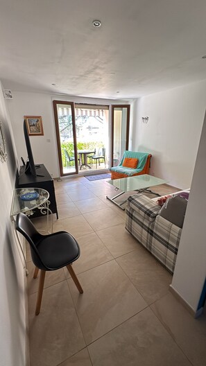 A compact living space with a kitchenette, a dining area, and a seating area with a view to the outside. - Newly renovated apartment in the center of Saint Raphaël. (Saint-Raphaël)