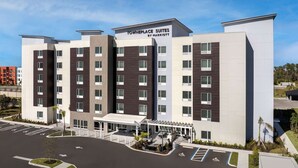 A hotel with a modern design, featuring a central entrance with a covered patio area. - Pet-Friendly Stay | Pool, Free Breakfast + Full Kitchen (Fort Myers)