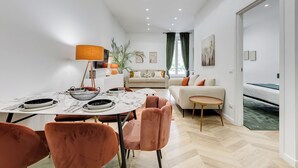 Ein modernes Wohnzimmer mit einer Couch, einem Esstisch und Stühlen.