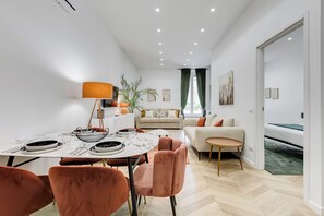 A modern living room with a sofa, dining table, and chairs. - Heart St Peter - Rome Dream Home (Roma)