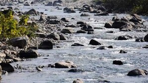 Une rivière bordée de rochers et de végétation.