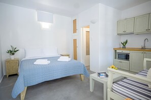 Ein Schlafzimmer mit Bett, Nachttisch und einer kleinen Küche.